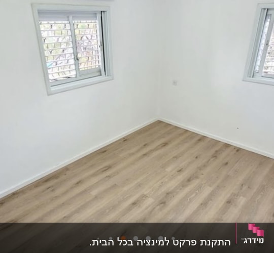 רצפת פרקט עץ בהירה בחדר ריק עם חלונות